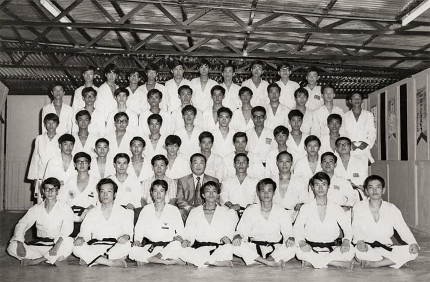Bok Man Kim seated with his black-belt students